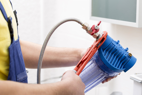 Licensed plumber installing water filtration system with clear upfront pricing